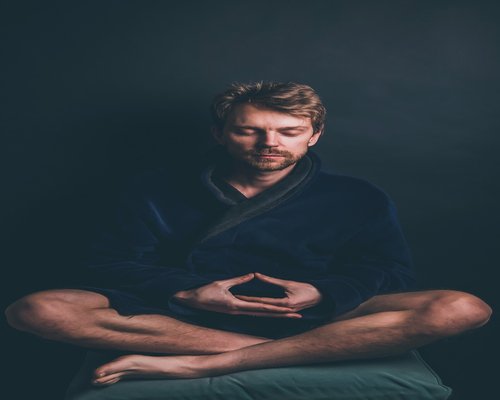 Person relaxing and meditating in a peaceful room
